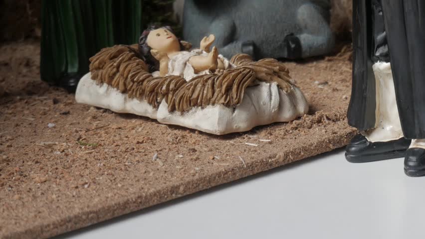 A close-up shot focuses on the baby Jesus figurine in the manger, flanked by a calf, one of the kings, and Mary. This beautifully crafted scene captures the essence of Christmas.