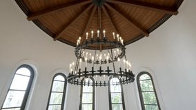 Interior of room with dom shaped ceiling. Ceiling exposed wooden beams radiating from central point. Large, circular chandelier hanging from ceiling with multiple lit candles - Powered by Shutterstock - Get 15% off with code: PIKWIZARD15