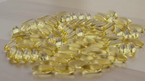 A detailed image showcasing a collection of fish oil capsules spread across a wooden table. The translucent golden capsules glisten, emphasizing health and wellness concepts. - Powered by Shutterstock - Get 15% off with code: PIKWIZARD15