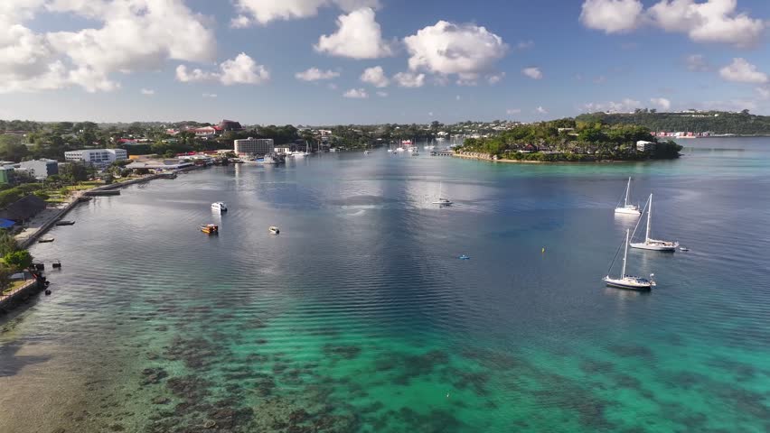 Port Vila, Efate, Vanuatu - A Coastal Tropical City With Boats and Yachts Anchored in the Harbor Beneath a Sky Filled With Fluffy Clouds - Aerial Drone Shot