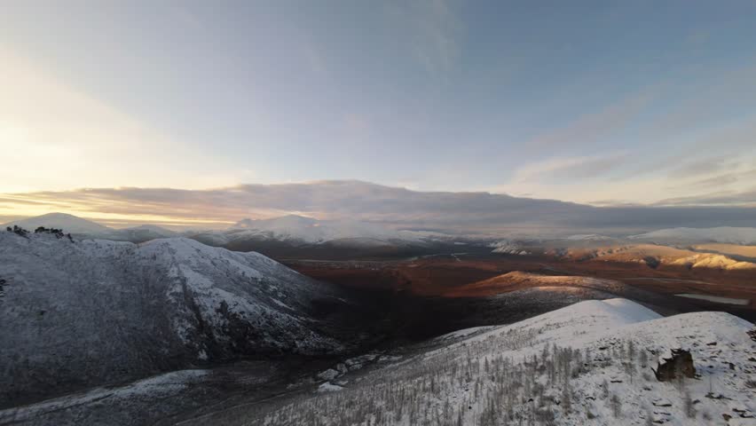 Experience a mesmerizing aerial exploration of Yakutia's pristine winter scenery as the sun sets, casting golden hues over the untouched snow. Nature’s beauty unfolds in every frame.