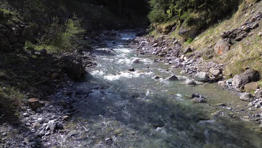 Aerial view of River in Austrian Nature surrounded by Forest and Mountain Landscape