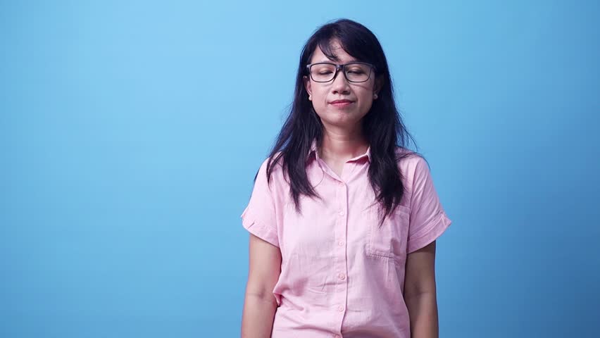 Wow excited young Asian woman looking something or copy space for product or sign text on aside. Isolated on blue background in studio.