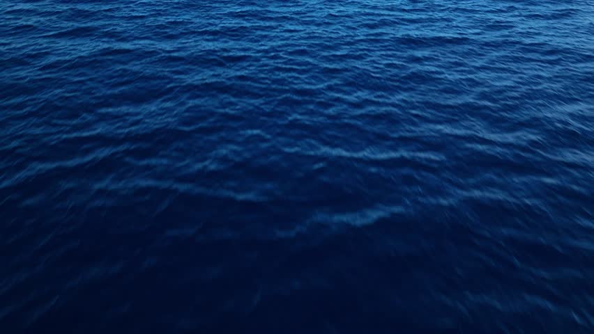 Aerial view of ocean with a vast blue surface, creating a tranquil and meditative background, push in and tilt up