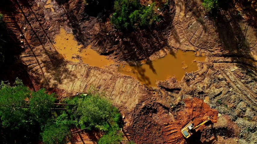 Aerial View of Active Mining Site with Excavation Machinery in Rugged Terrain