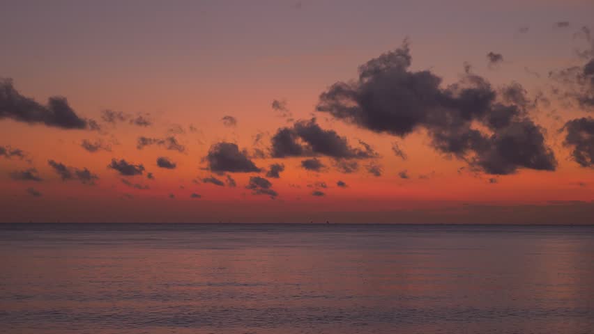 Dark surface of calm ocean and red sky before sunrise. Location: Amed Bali Indonesia