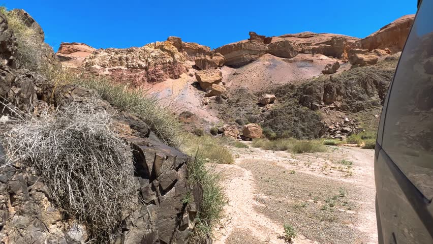 Charyn Canyon in Kazakhstan. The view from the car window of the amazing canyon in Central Asia. Mountain ranges in a fabulous canyon. Landscape above a rocky canyon on the Charyn River trail. 4К 