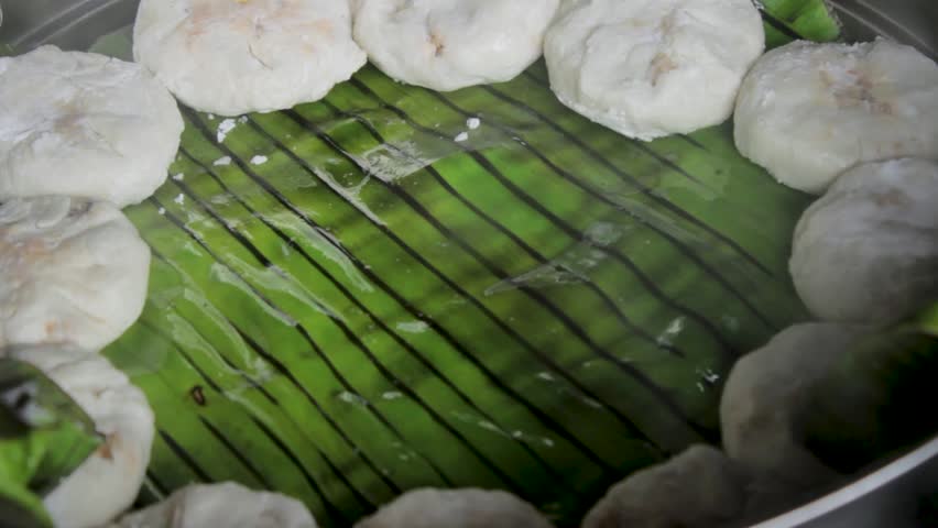 cooking dumplings, steam the dumplings on the streamer using banana leave. Streamed vegeterian dumplings chinese food