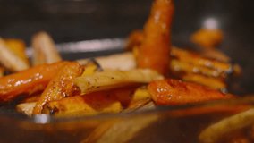 Spoon Coating Freshly Oven Roasted British Carrots and Parsnips in Olive Oil in Slow Motion Getting Ready to Serve 4K - Powered by Shutterstock - Get 15% off with code: PIKWIZARD15