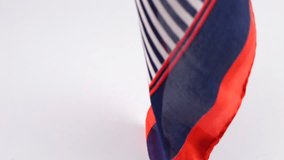 A light silk scarf in blue, white and red stripes slowly falls in soft folds on a white background. Slow motion. - Powered by Shutterstock - Get 15% off with code: PIKWIZARD15