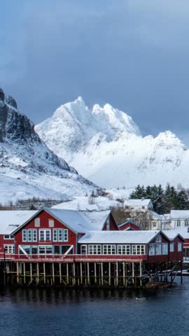 Timelapse of traditional fishing village A on Lofoten Islands, Norway with red rorbu houses. With snow in winter. Zoom out effect