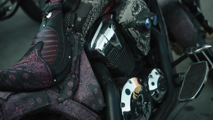 Classic customised motorcycle details parked outside in a cloudly weather .