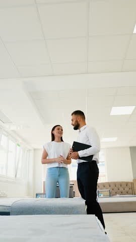 Salesman Assists Customer in Choosing the Mattress