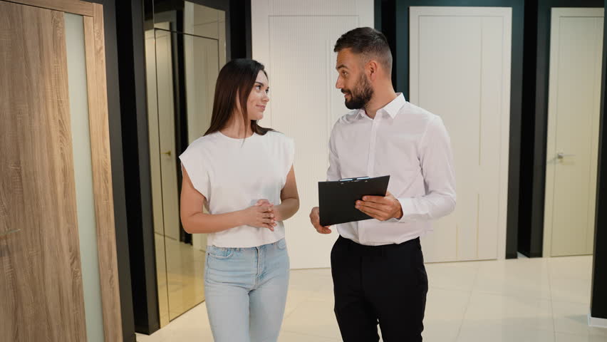 Consultant Assisting Woman in Selecting Door Options in Showroom