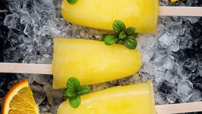 Refreshing homemade orange popsicles with mint served on ice - Powered by Shutterstock - Get 15% off with code: PIKWIZARD15