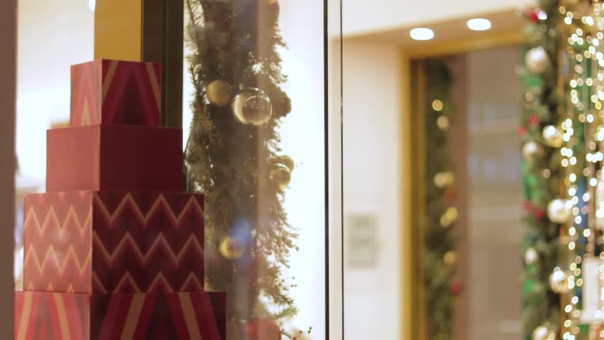 Shop display window decorated with christmas gifts, garland and lights.
