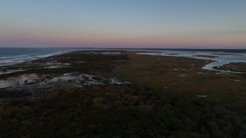 Cape cod marsh and dunes at sunset with colorful autumn foliage and water channels, aerial view