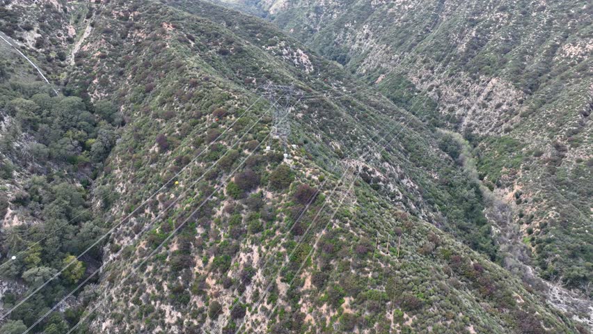 Aerial shot of power lines running through the rugged San Gabriel Mountains near Los Angles California