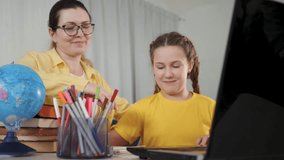 mother teaching kid online at home. Woman pointing at computer screen helping child learn online. Homeschooling concept. Multigenerational family learning online. Kid study on computer at home - Powered by Shutterstock - Get 15% off with code: PIKWIZARD15