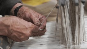 An elderly man meticulously weaves a delicate fabric using a old antique traditional wooden loom, demonstrating skill and patience in Ladakh, india - Powered by Shutterstock - Get 15% off with code: PIKWIZARD15