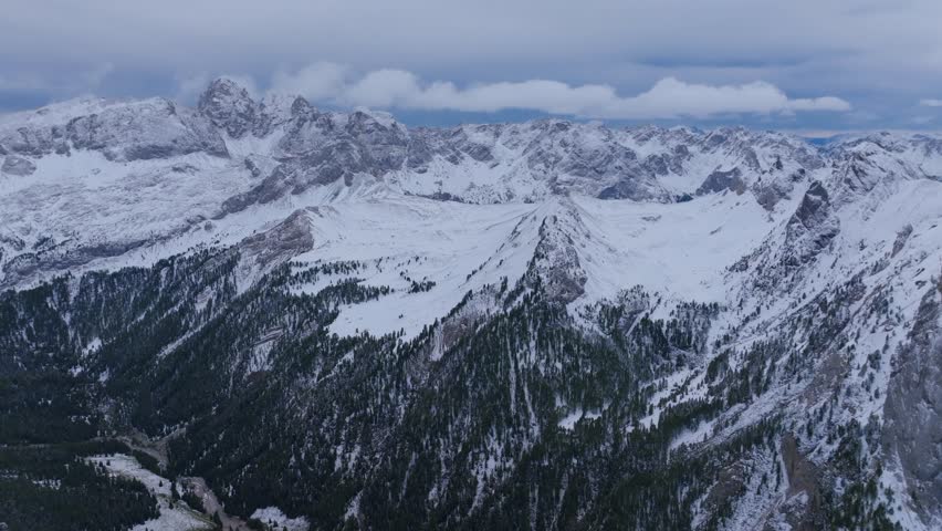 Beautiful view of high hills mountains covered with snow and clouds 