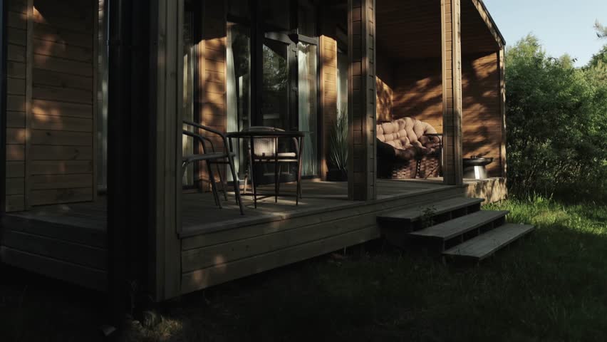 Charming Wooden Cabin Featuring a Cozy Porch Surrounded by Serene Green Environments