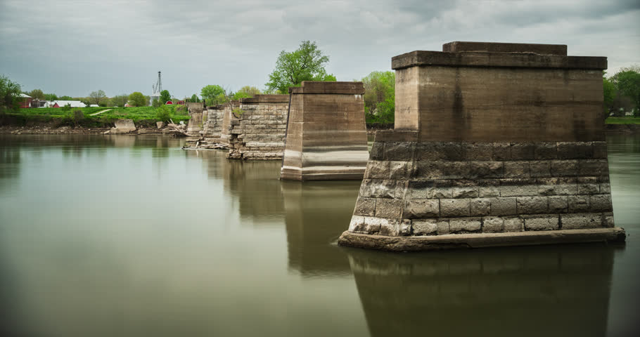 Turn of the century (1901) limestone bridge pilings stand unyielding and firm on the Des Moines River outside the midwest community of Eldon, Iowa. 