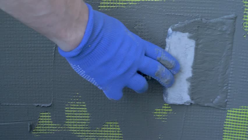 Installed yellow plastic on building wall. Vapour barrier for thermal wall insulation. Exterior cladding. Fiberglass mesh wall plaster grid yellow colour. External wall insulation system EWIS