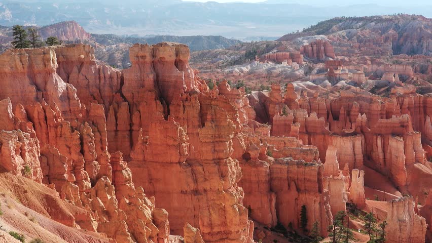 Discover the breathtaking landscapes of Bryce Canyon featuring dramatic red rock formations, towering cliffs, and vast vistas under a clear blue sky.