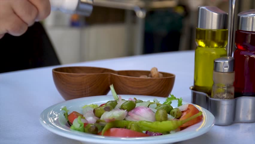 Slow motion, close-up of a person adding salt to a salad with a salt shaker - Powered by Shutterstock - Get 15% off with code: PIKWIZARD15