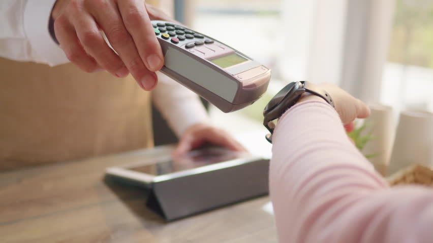 Woman paying for purchase with smart watch close up. NFC technology concept. Online digital payment system with POS terminal