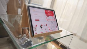 Woman scanning face on tablet for secure cashless payment close up. Biometric ID verification. Customer paying for purchase with identity authentication - Powered by Shutterstock - Get 15% off with code: PIKWIZARD15