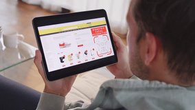 Caucasian man scanning face on tablet for secure online payment, over shoulder view. Internet shopping at home and biometric ID verification concept - Powered by Shutterstock - Get 15% off with code: PIKWIZARD15