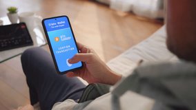 Man paying with crypto wallet, holding smartphone in hand, confirming transaction with fingerprint scan, over shoulder view. Biometric security and cryptocurrency payment - Powered by Shutterstock - Get 15% off with code: PIKWIZARD15