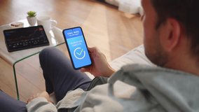 Man confirming cryptocurrency payment with biometric fingerprint scanner on mobile phone, over shoulder view. Using smartphone for crypto wallet payment verification - Powered by Shutterstock - Get 15% off with code: PIKWIZARD15