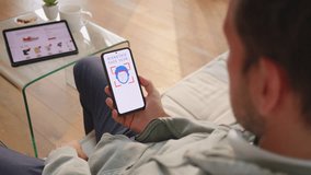 Man using face recognition on smartphone to confirm cashless transaction, over shoulder view. Online shopping and secure digital banking concept - Powered by Shutterstock - Get 15% off with code: PIKWIZARD15