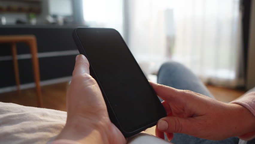 Woman paying with crypto wallet on smartphone close up. Buyer clicking button on mobile screen wile making cryptocurrency payment online closeup