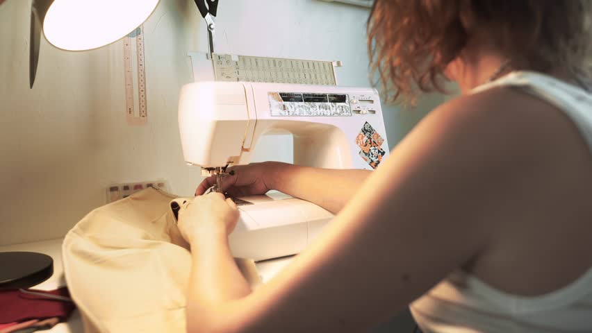 Needlecraft and sewing business: woman works at home with sewing machine, creating custom designs. Freelancers and small business owners, scene showcases needlecraft and sewing business creativity