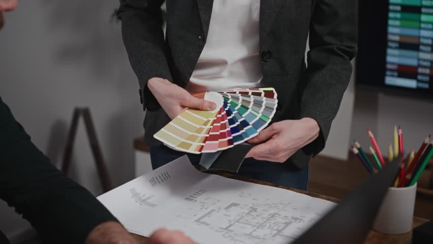 Unrecognizable interior designers select materials and color schemes for a modern apartment project. Teamwork in an architectural studio.