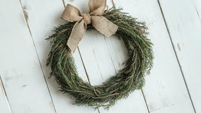 Simple Rustic Christmas Wreath With Burlap Bow on White Wooden Wall - Powered by Shutterstock - Get 15% off with code: PIKWIZARD15