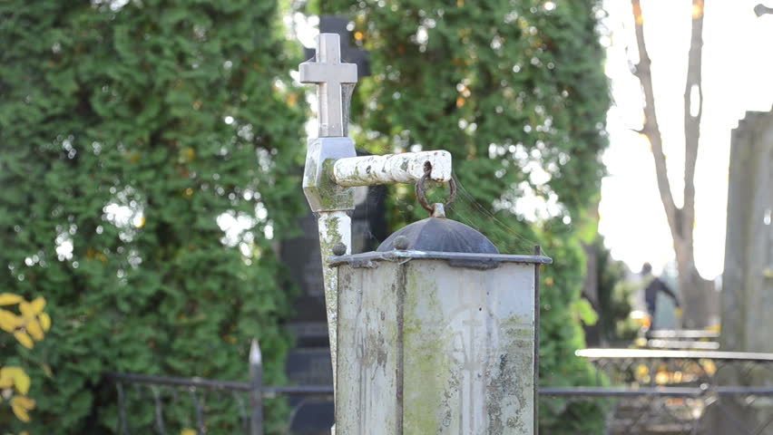 old retro religion cross and decorative lamp light hood move near cemetery graveyard.