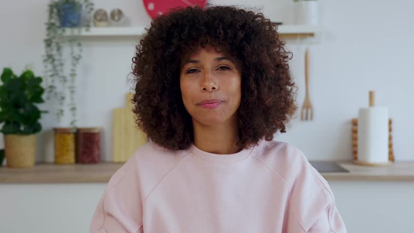 POV or portrait screen view of young African American pretty woman talking on laptop computer video call in the kitchen at home. Business people and virtual conference concept.