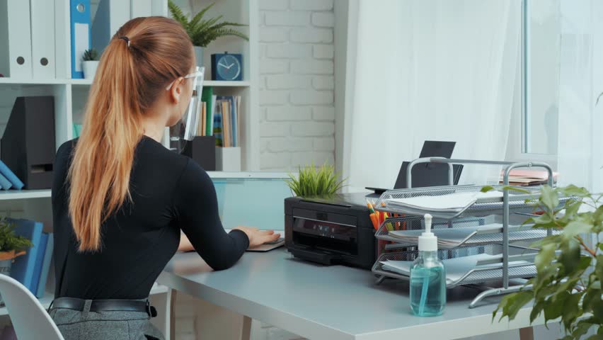 Organizing an efficient home office workspace in a bright, modern room with a focus on productivity and comfort
