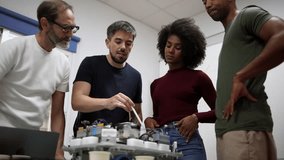 Multi generational and multiracial team of engineers working together on a complex robotics project, demonstrating teamwork and expertise in a modern laboratory setting - Powered by Shutterstock - Get 15% off with code: PIKWIZARD15