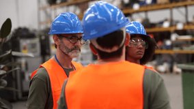 Multiracial team of engineers wearing safety vests and hardhats discussing a project in a factory setting, showcasing teamwork and expertise in an industrial environment - Powered by Shutterstock - Get 15% off with code: PIKWIZARD15