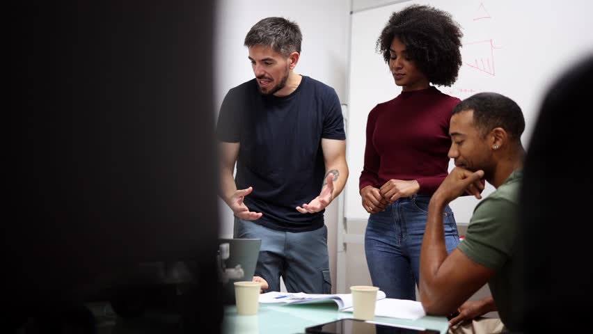 Diverse engineers collaborate on robotics project in modern factory, fostering innovation and teamwork