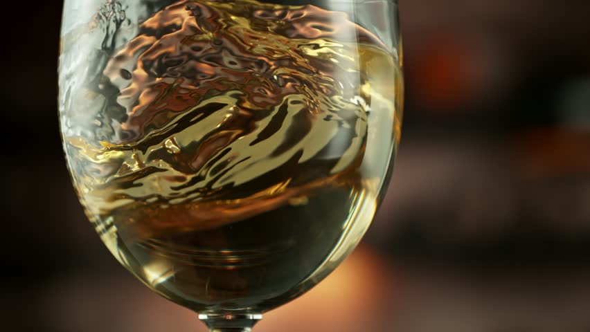 Super Slow Motion Detail Shot of Spinning White Wine in Glass at 1000fps.