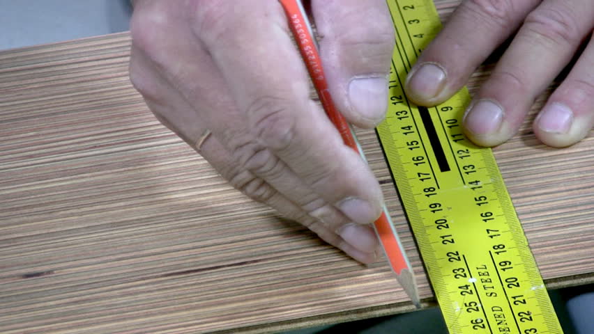 Men's hand draw a pencil line on the laminate. Men's hands are doing sawing with