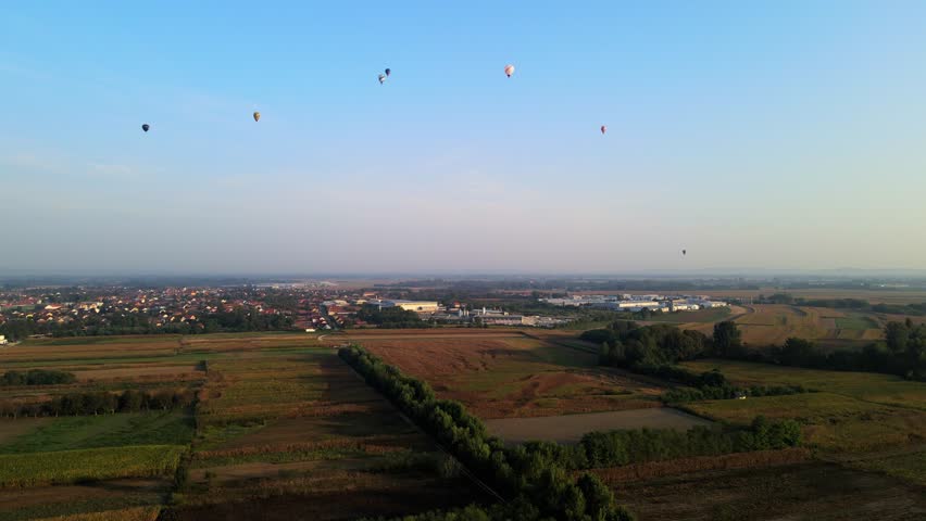Stunning 4K aerial footage of a drone filming hot air balloons. Flying over farming fields and river. Filmed on a beautiful summer morning. Part of a hot air ballon festival in Prelog, Croatia.