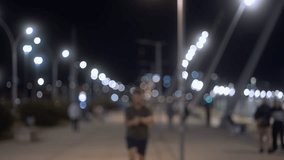 Joyful runner checking time on smartwatch after evening run. Smiling man in casual wear celebrating his workout progress under city lights at night. - Powered by Shutterstock - Get 15% off with code: PIKWIZARD15